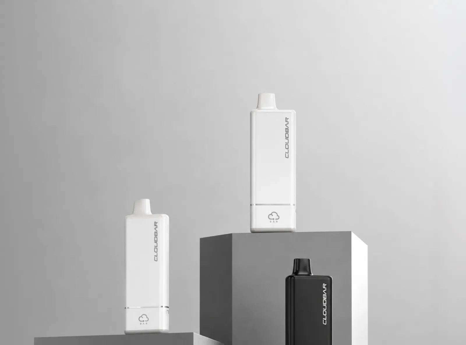Two white and one black CLOUDBAR disposable device on grey pedestal blocks in a grey studio
